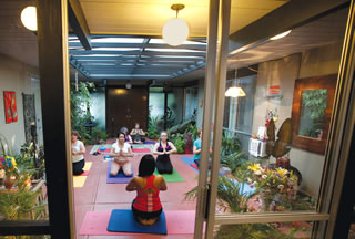 Prabha Gopal (in red) leads students during a session of “serious, classical yoga” in her Walnut Creek Eichler.