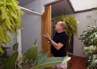 San Jose Eichler owner David Winn looks up to one of his atrium’s finch visitors. 